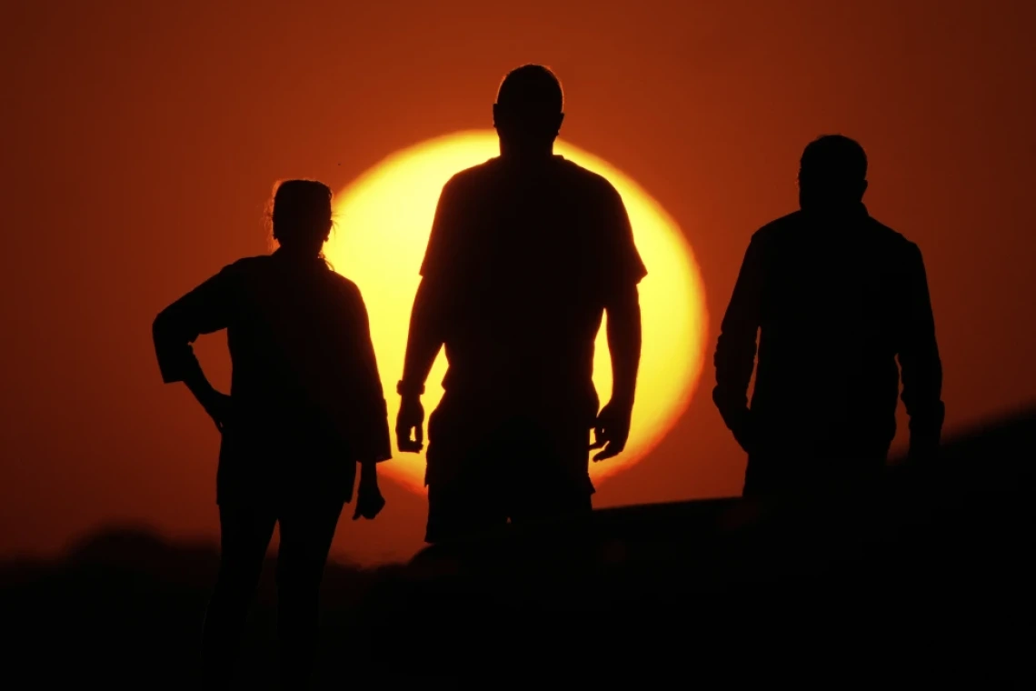 People watch the sunset from the Liberty Memorial grounds in Kansas City, Mo., May 12, 2025. (AP Photo/Charlie Riedel, File)